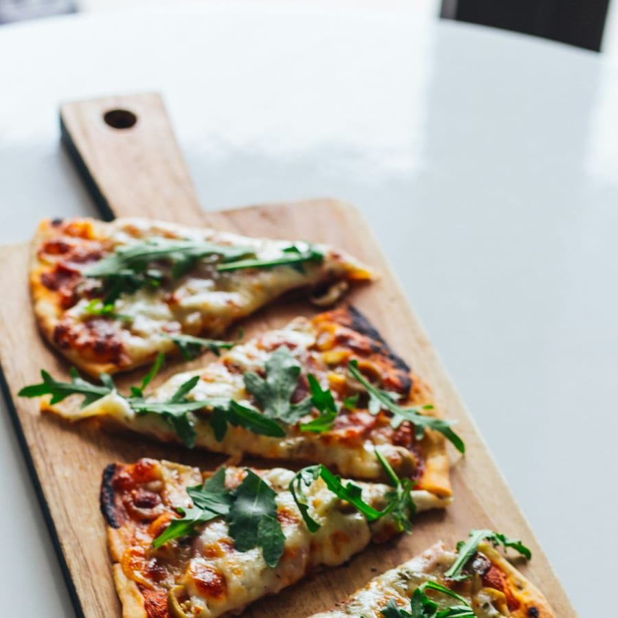 Pizza auf einem runden Holzbrett
